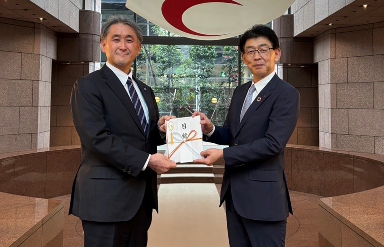 2025年12月25日に実施した贈呈式での、目録贈呈の様子の写真です。